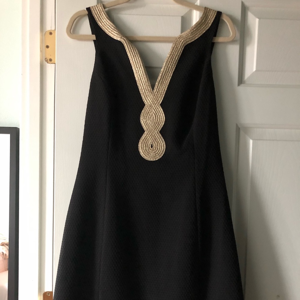 Black textured fabric with light gold trim detail